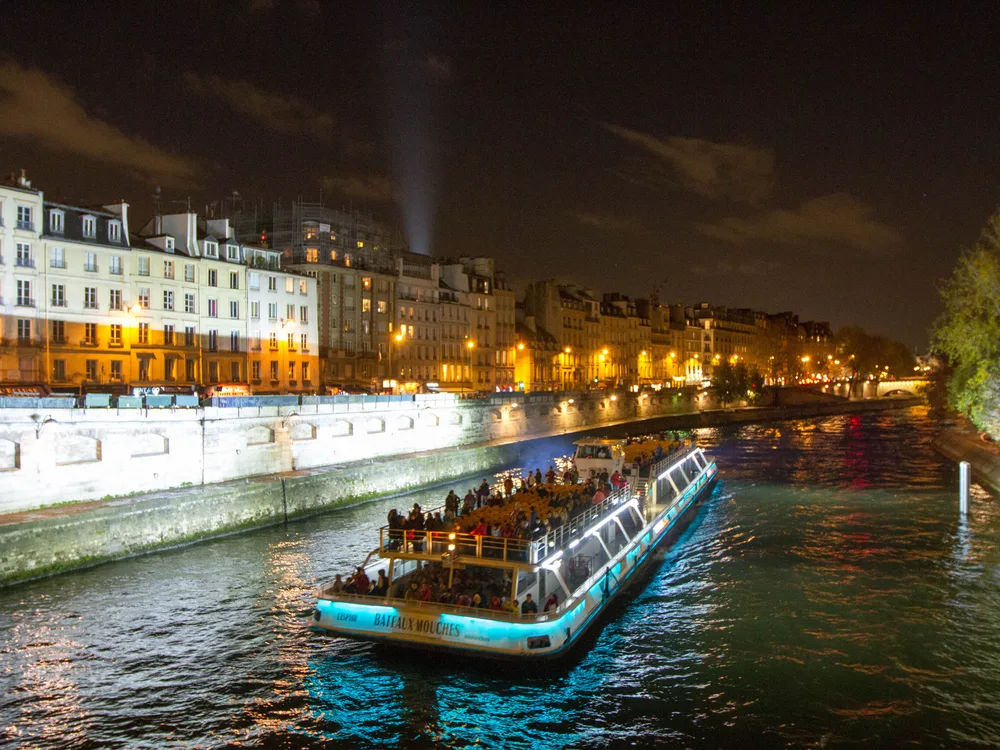 A Bateaux Mouches cruise boat lit up on the Seine at night